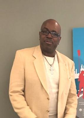 dwayne adams in a cream-colored suit jacket