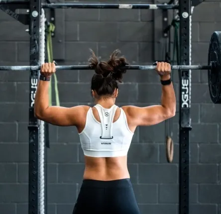 a woman lifts a weight above her head