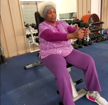 a senior citizen uses light weights during a training session