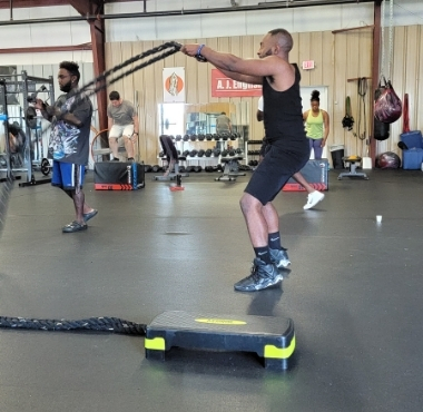 a muscular black man uses ropes during a workout