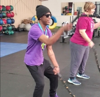 a blind man uses ropes during a group workout